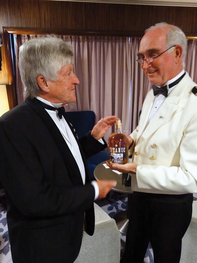 The Captain of the Saga Sapphire Philip Rentall presents Des Cox with the first bottle of Titanic Whiskey.